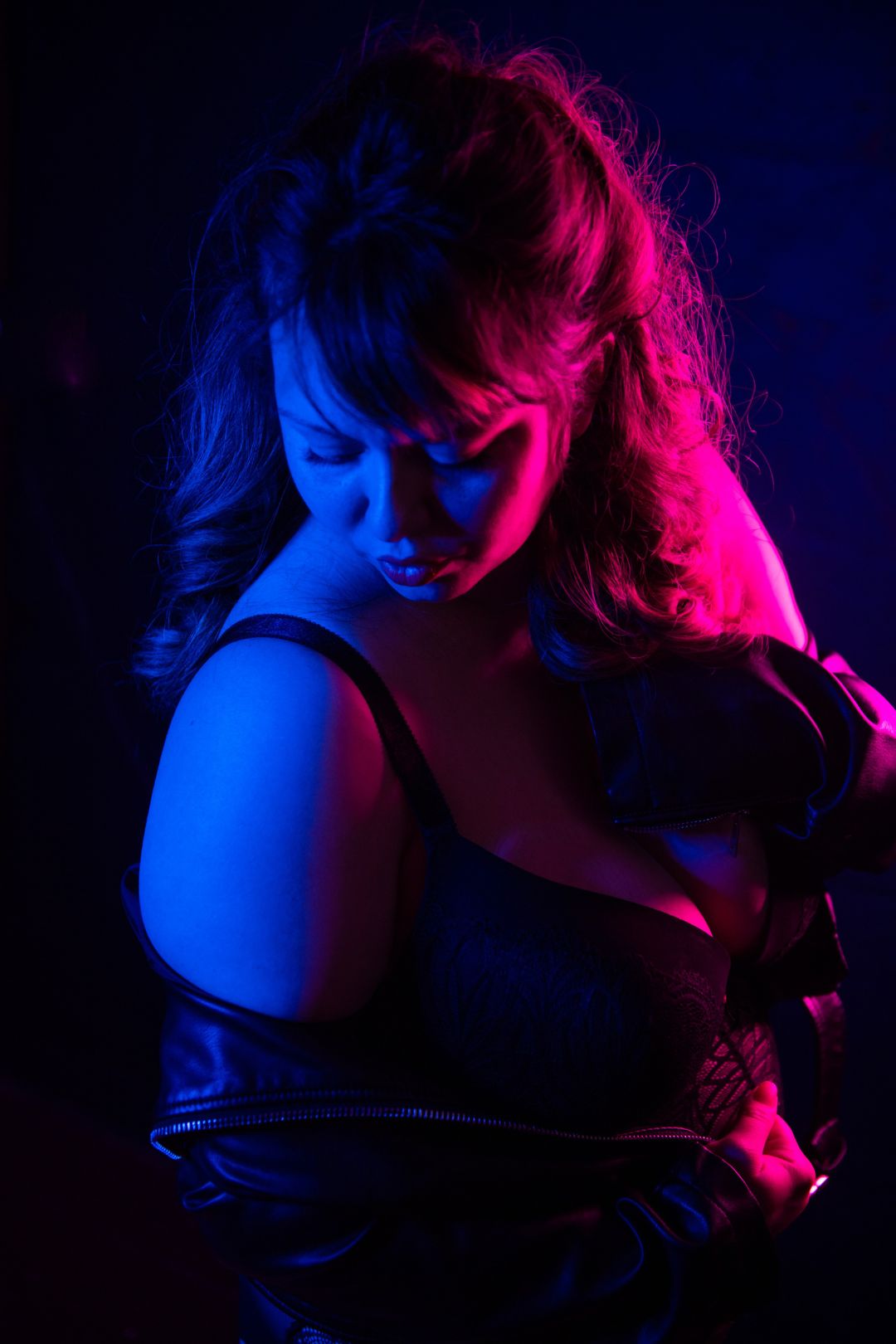 Photoshoot of a woman in red and blue neon room